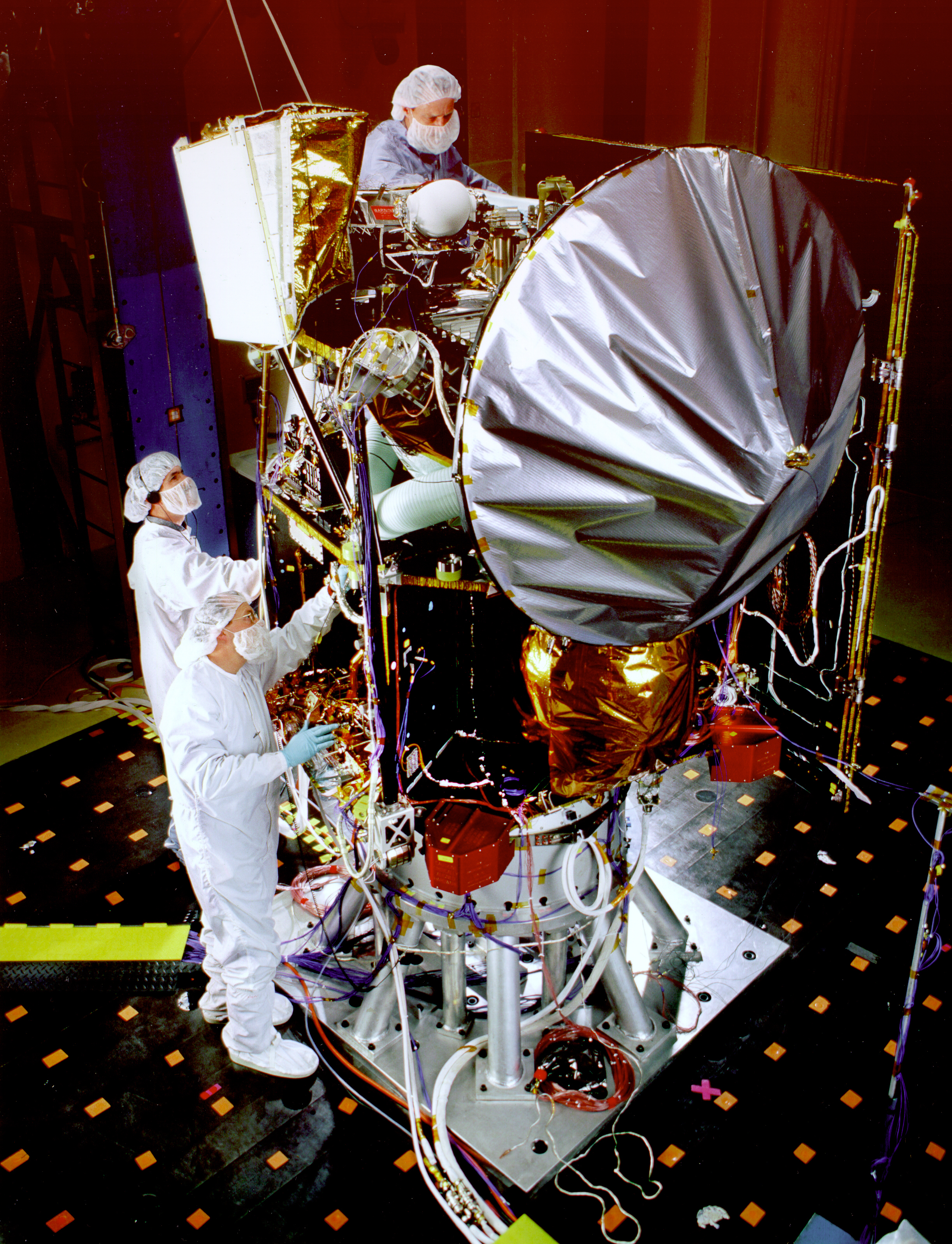 Historical photograph H1. Technicians with Mars Climate Orbiter during acoustic testing, 27 May 1998. Flight hardware, instruments, and test equipment bring the system's physical interfaces into view. NASA, GPN-2000-000498.